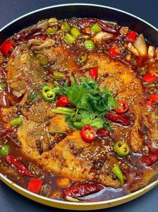 川香烤鱼的做法_鱼盘准备烤制，调味炒菜铺鱼上，鲜嫩麻辣好滋味